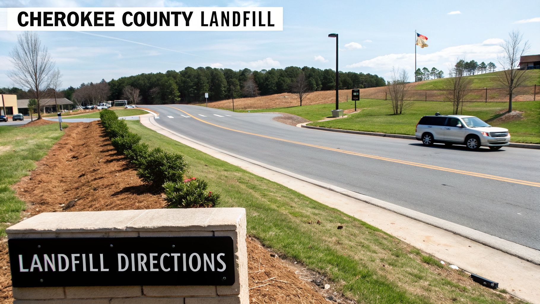 A clear image of the Cherokee County Landfill entrance with a 'LANDFILL DIRECTIONS' sign and a car on the road.